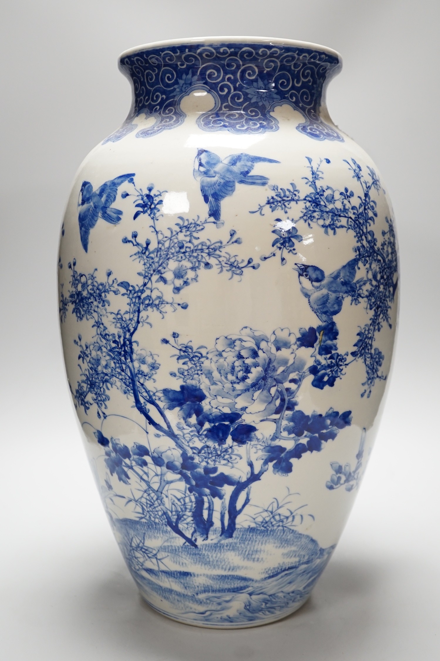 A large Japanese blue and white vase decorated with foliage and birds, 49cms high